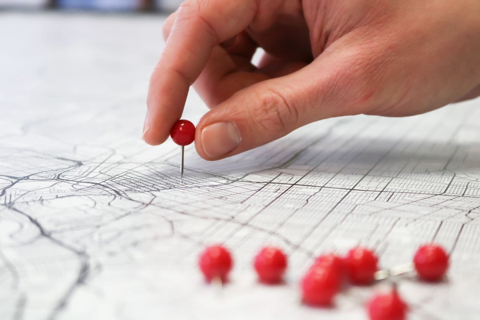 Être la bonne épingle sur la carte Une main place une épingle rouge sur un plan de ville, symbole du positionnement local sur Google Maps - SimplerWebs