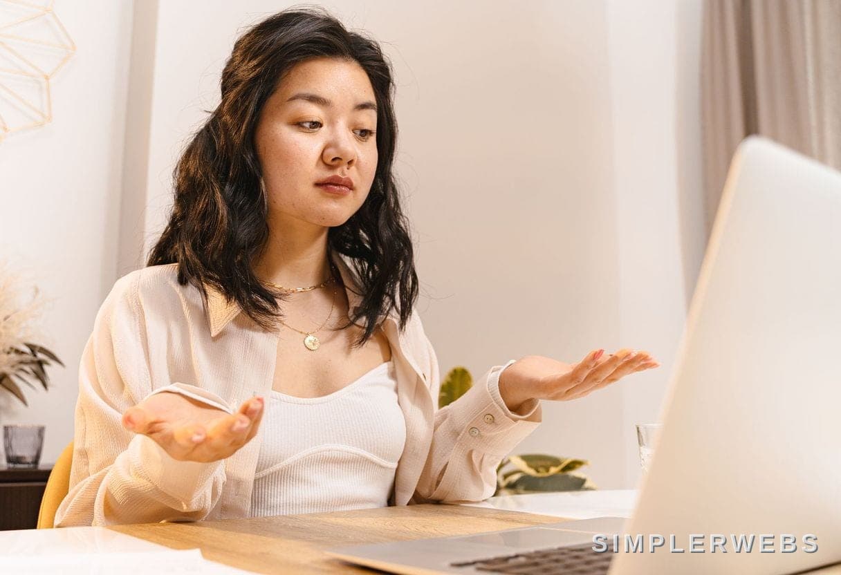 Un plan clair, au lieu de tourner en rond Une propriétaire d'entreprise réfléchit devant son ordinateur portable - SimplerWebs