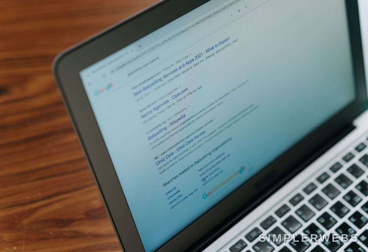 Être cité comme source par l'IA Une personne travaille sur un ordinateur portable avec une recherche IA à l'écran - SimplerWebs